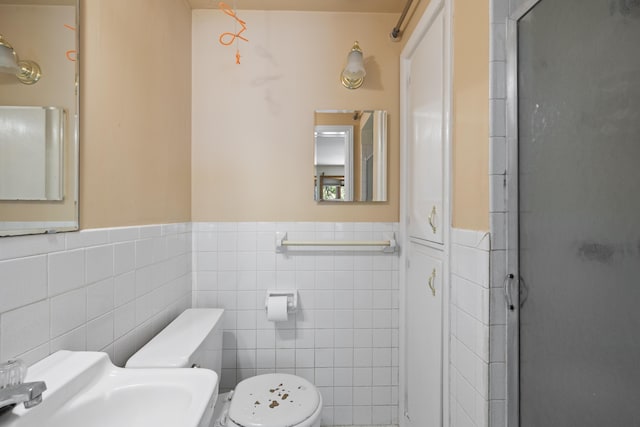 2266 E Barataria St, Springfield, MO 65804 - bathroom with tile walls, a stall shower, and a wainscoted wall