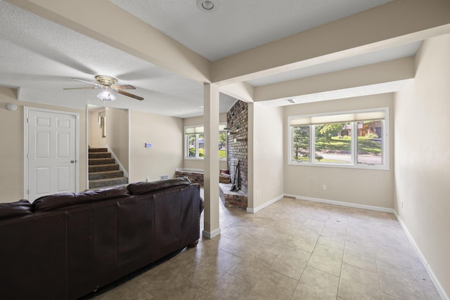 2266 E Barataria St, Springfield, MO 65804 - living area with ceiling fan, stairway, light tile patterned floors, and a textured ceiling