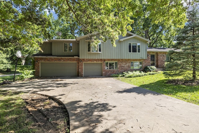 2266 E Barataria St, Springfield, MO 65804 - view of front of house with an attached garage, driveway, brick siding, a front yard, and board and batten siding