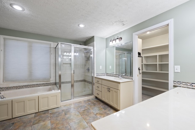 2266 E Barataria St, Springfield, MO 65804 - full bath with vanity, a stall shower, a bath, a walk in closet, and a textured ceiling