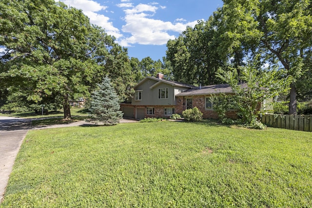 2266 E Barataria St, Springfield, MO 65804 - tri-level home with brick siding, an attached garage, a chimney, and driveway