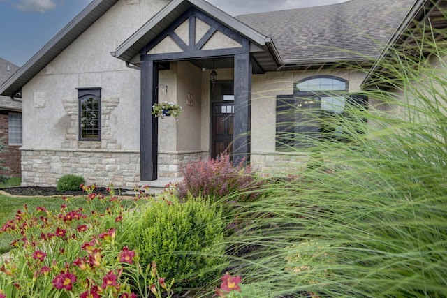 4604 E Kentbrook Dr, Springfield, MO 65802 - view of exterior entry with stucco siding, stone siding, and a shingled roof