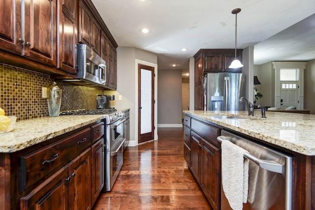 4604 E Kentbrook Dr, Springfield, MO 65802 - kitchen featuring stainless steel appliances, tasteful backsplash, dark wood-style flooring, light stone counters, and decorative light fixtures