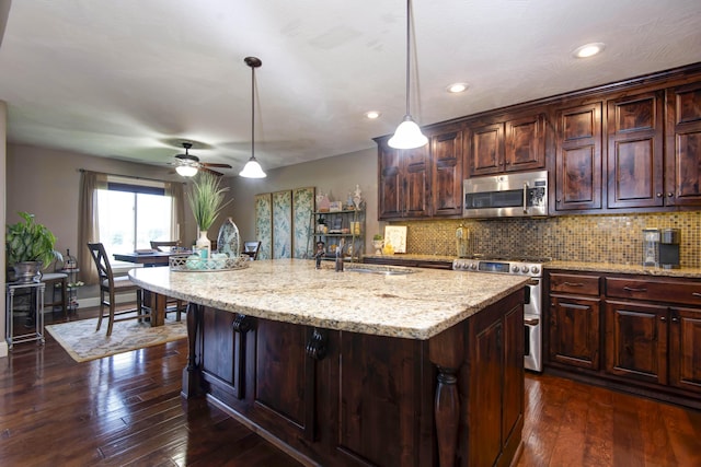 4604 E Kentbrook Dr, Springfield, MO 65802 - kitchen with appliances with stainless steel finishes, backsplash, dark wood-style floors, light stone countertops, and recessed lighting