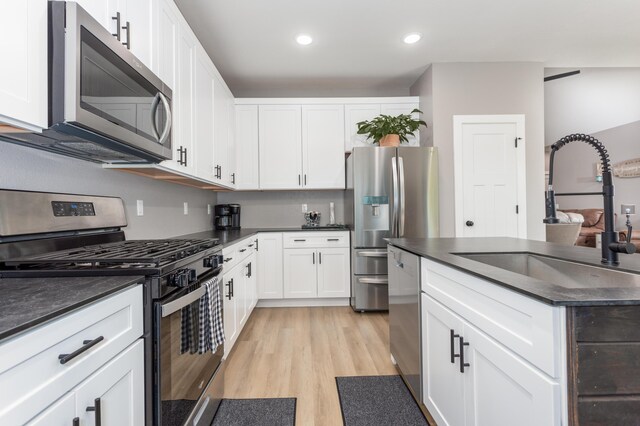 622 N Dean Ln, Republic, MO 65738 - kitchen featuring appliances with stainless steel finishes, dark countertops, light wood-type flooring, white cabinets, and recessed lighting