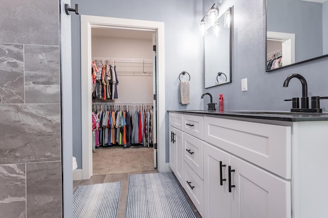 622 N Dean Ln, Republic, MO 65738 - bathroom with double vanity, a spacious closet, and tile patterned flooring