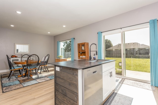 622 N Dean Ln, Republic, MO 65738 - kitchen featuring dishwasher, a kitchen island with sink, dark countertops, white cabinets, and light wood-style flooring