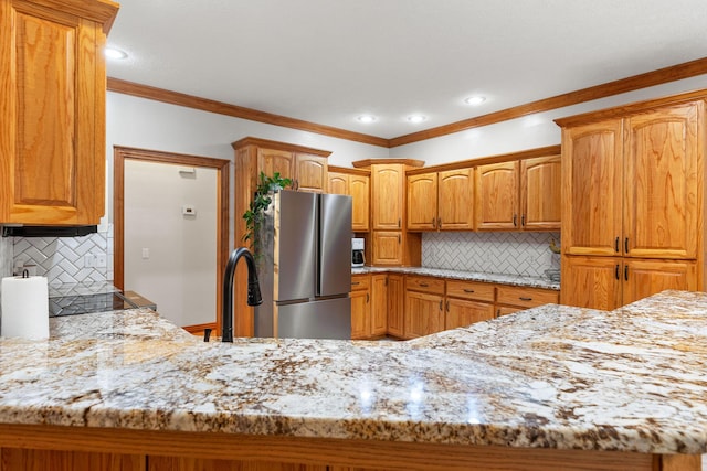 217 E Grace St, Republic, MO 65738 - kitchen featuring freestanding refrigerator, tasteful backsplash, light stone countertops, crown molding, and brown cabinets