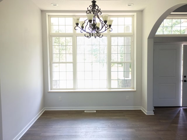 6540 Gateway Dr, Joplin, MO 64804 - unfurnished dining area with arched walkways, a chandelier, and dark wood finished floors