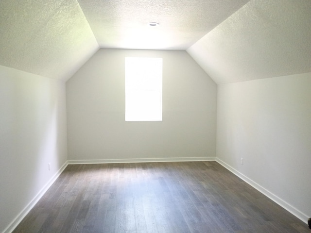 6540 Gateway Dr, Joplin, MO 64804 - bonus room featuring dark wood-style flooring, a textured ceiling, and vaulted ceiling