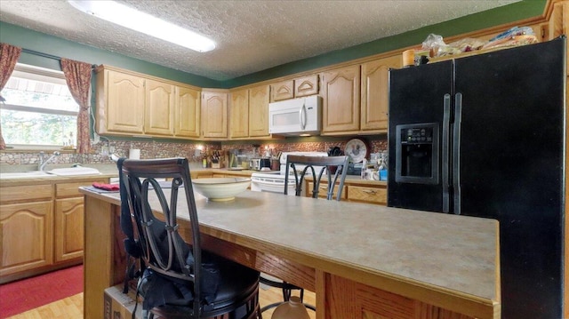 1339 W Business Highway 60-63, Willow Springs, MO 65793 - kitchen with white appliances, light brown cabinets, light countertops, a kitchen breakfast bar, and a textured ceiling