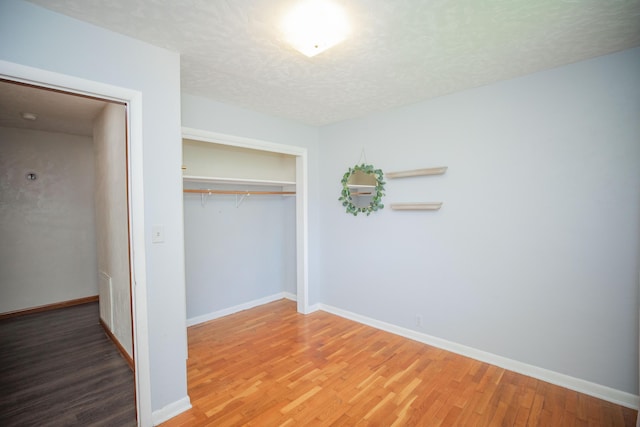 619 Rte H, Greenfield, MO 65661 - unfurnished bedroom with wood finished floors, a closet, and a textured ceiling