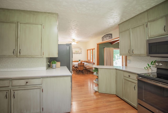 619 Rte H, Greenfield, MO 65661 - kitchen featuring stainless steel appliances, light countertops, light wood finished floors, a textured ceiling, and a peninsula