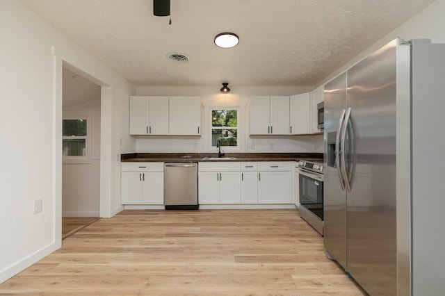 2716 W Elm St, Springfield, MO 65802 - kitchen with stainless steel appliances, dark countertops, white cabinetry, and a textured ceiling