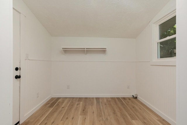 2716 W Elm St, Springfield, MO 65802 - laundry room featuring light wood-style flooring, a textured ceiling, and a wainscoted wall