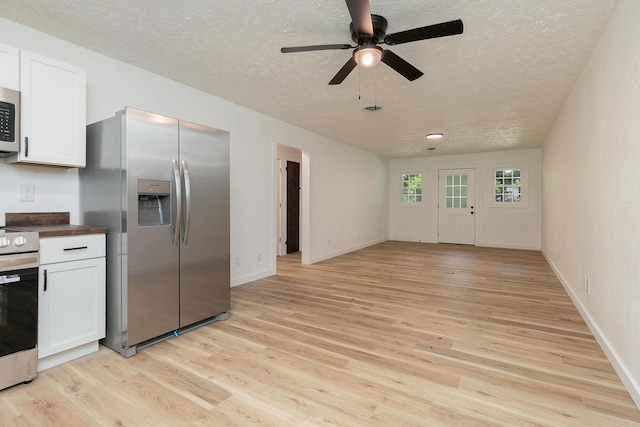 2716 W Elm St, Springfield, MO 65802 - kitchen with appliances with stainless steel finishes, a textured ceiling, light wood-type flooring, a ceiling fan, and white cabinets