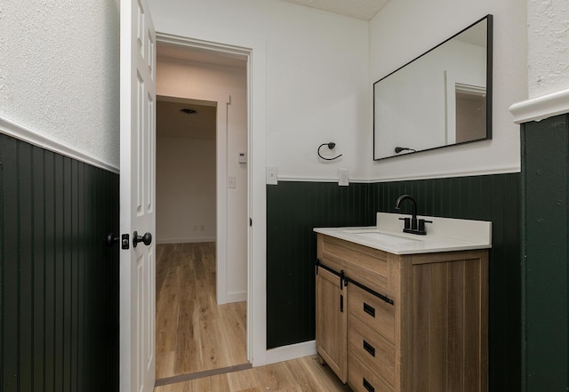 2716 W Elm St, Springfield, MO 65802 - bathroom with wainscoting, vanity, wood finished floors, and wooden walls