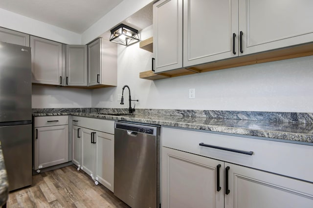 2525 New Hampshire Ave, Joplin, MO 64804 - kitchen featuring stainless steel appliances, light wood finished floors, gray cabinets, and dark stone counters