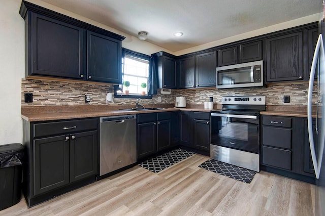 579 Lantern Hill Rd, Nixa, MO 65714 - kitchen with appliances with stainless steel finishes, light wood finished floors, and decorative backsplash