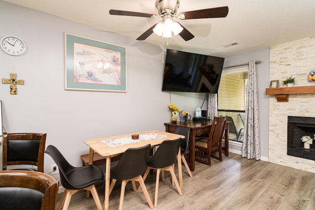 320 Turnberry Rd # 2, Branson, MO 65616 - dining room with light wood-style floors, a ceiling fan, and a stone fireplace