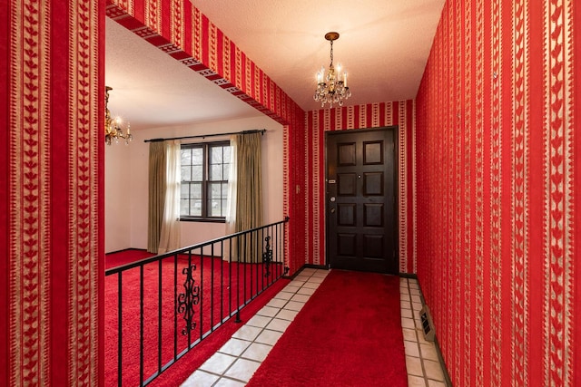 2311 E Meadow Dr, Springfield, MO 65804 - tiled foyer featuring a chandelier, wallpapered walls, and a textured ceiling