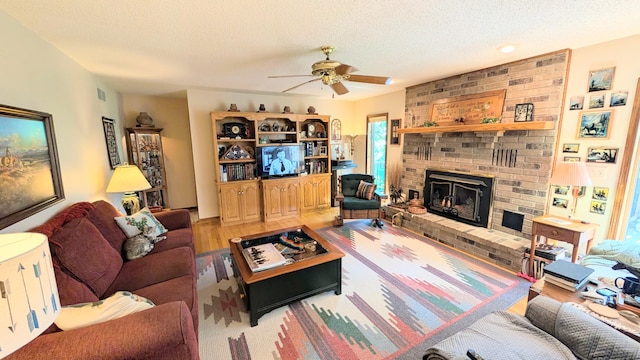 2930 S 175th Rd, El Dorado Springs, MO 64744 - living area with ceiling fan, a brick fireplace, wood finished floors, a textured ceiling, and plenty of natural light