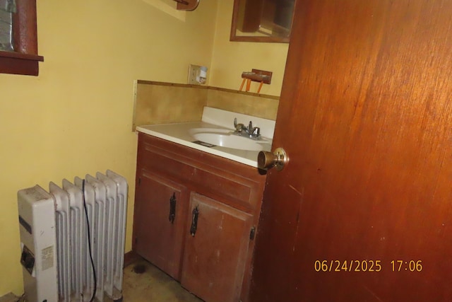 321 W Cofield St, Aurora, MO 65605 - bathroom with radiator heating unit, vanity, and concrete flooring