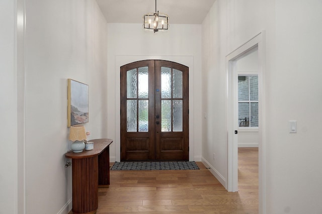 3945 E Woodhue St, Springfield, MO 65802 - foyer entrance with wood finished floors, arched walkways, french doors, and a chandelier