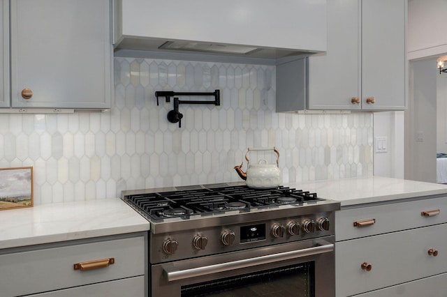3945 E Woodhue St, Springfield, MO 65802 - kitchen featuring high end stainless steel range oven, ventilation hood, tasteful backsplash, and light stone countertops