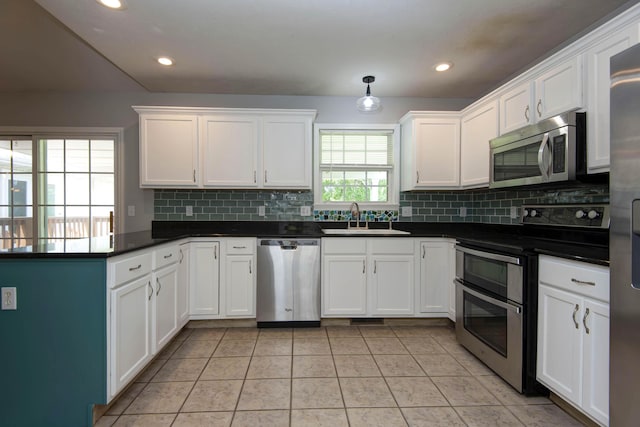 805 S Benson Pl, Nixa, MO 65714 - kitchen with appliances with stainless steel finishes, tasteful backsplash, a peninsula, white cabinetry, and recessed lighting