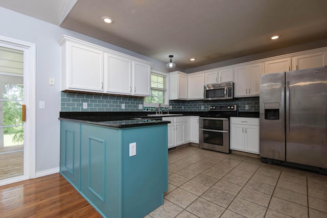 805 S Benson Pl, Nixa, MO 65714 - kitchen with stainless steel appliances, dark countertops, white cabinetry, tasteful backsplash, and a peninsula