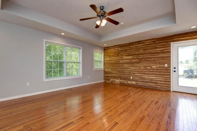 805 S Benson Pl, Nixa, MO 65714 - unfurnished room with light wood-style flooring, plenty of natural light, ceiling fan, wooden walls, and a textured ceiling