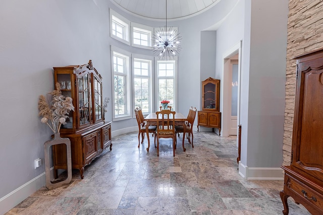 6323 Creeksedge Ct, Ozark, MO 65721 - dining space featuring a chandelier, stone tile floors, and a towering ceiling