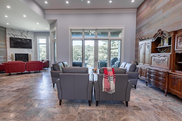 6323 Creeksedge Ct, Ozark, MO 65721 - living room with stone tile floors, wood walls, a fireplace, recessed lighting, and a high ceiling