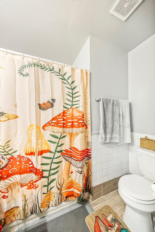 2515 S Newton Ave, Springfield, MO 65807 - full bath with tile walls, a wainscoted wall, curtained shower, and a textured ceiling