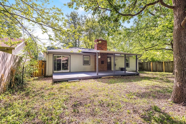2515 S Newton Ave, Springfield, MO 65807 - back of house featuring a chimney, a fenced backyard, and a wooden deck