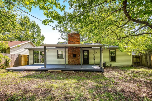 2515 S Newton Ave, Springfield, MO 65807 - rear view of property featuring a chimney, a fenced backyard, and a deck