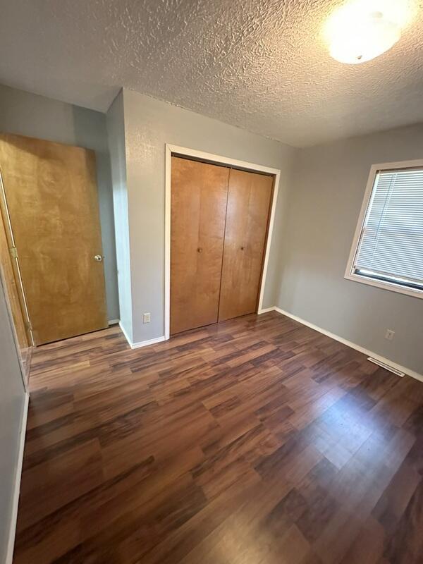 2201 S 18th Ave, Ozark, MO 65721 - unfurnished bedroom with a closet, dark wood finished floors, and a textured ceiling