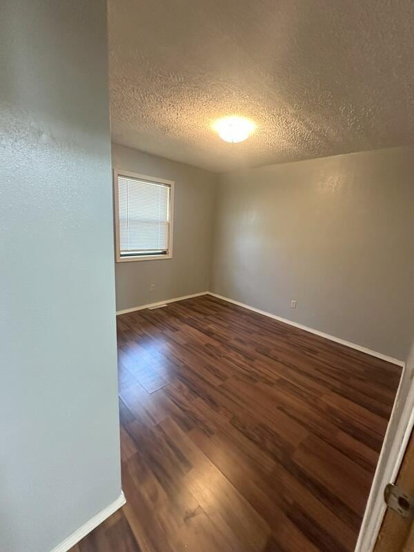 2201 S 18th Ave, Ozark, MO 65721 - spare room featuring a textured ceiling and dark wood-style flooring