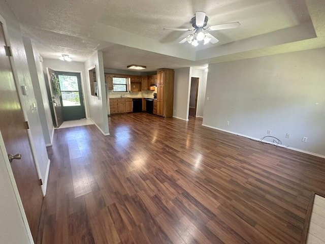 2201 S 18th Ave, Ozark, MO 65721 - unfurnished living room featuring dark wood-style flooring, ceiling fan, a textured ceiling, and a raised ceiling