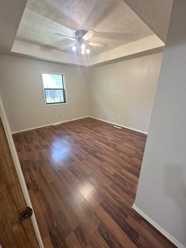 2201 S 18th Ave, Ozark, MO 65721 - empty room with a tray ceiling, a textured ceiling, wood finished floors, and a ceiling fan