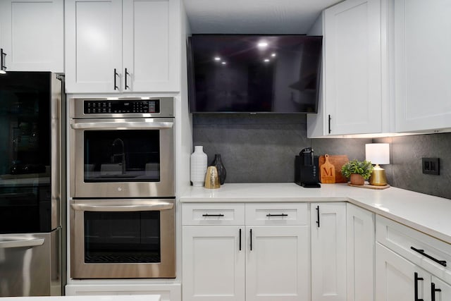 12163 State Highway Tt, Republic, MO 65738 - kitchen with stainless steel double oven, smart refrigerator, tasteful backsplash, and white cabinetry