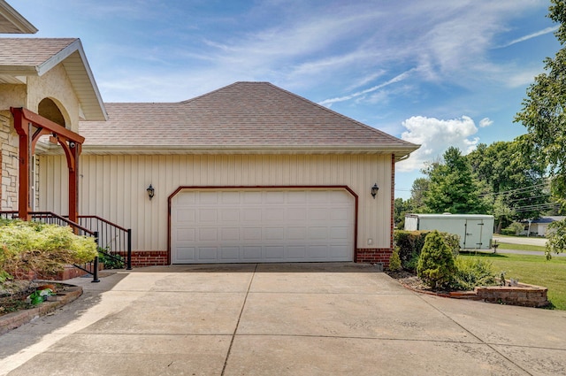 823 Mcvey St, Mount Vernon, MO 65712 - view of side of home with roof with shingles, brick siding, driveway, and a garage