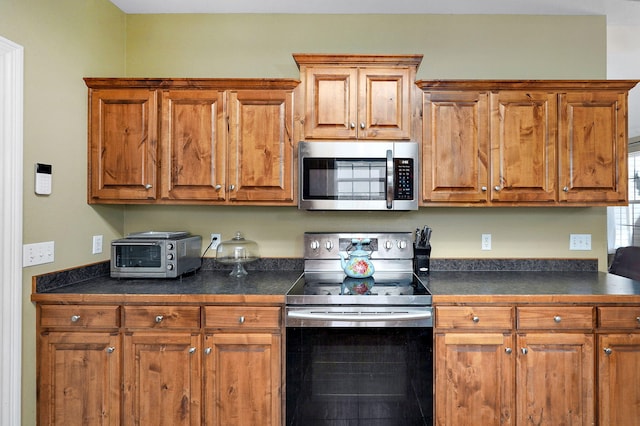 823 Mcvey St, Mount Vernon, MO 65712 - kitchen with appliances with stainless steel finishes, dark countertops, and brown cabinets