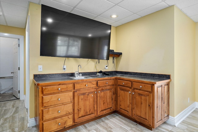 823 Mcvey St, Mount Vernon, MO 65712 - kitchen featuring dark countertops, brown cabinets, a drop ceiling, and light wood-style floors
