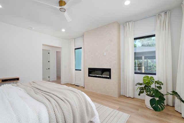104 Walnut Hill Ln, Ozark, MO 65721 - bedroom featuring recessed lighting, a fireplace, light wood finished floors, and a ceiling fan