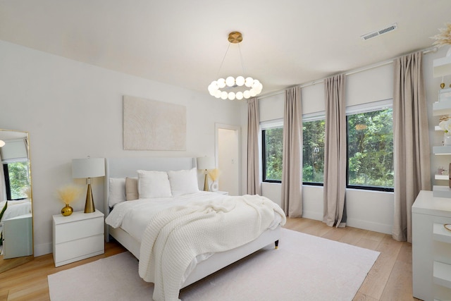 104 Walnut Hill Ln, Ozark, MO 65721 - bedroom featuring multiple windows, light wood-style floors, and a chandelier