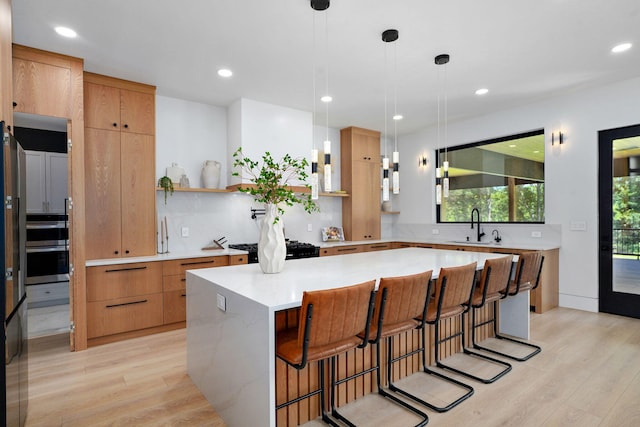 104 Walnut Hill Ln, Ozark, MO 65721 - kitchen featuring light wood-style floors, light countertops, modern cabinets, a kitchen breakfast bar, and recessed lighting
