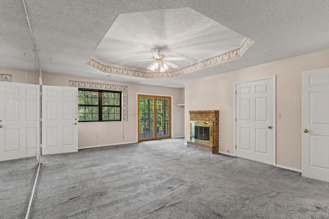 8756 W Farm Rd Unit 124, Springfield, MO 65802 - unfurnished living room with a textured ceiling, carpet flooring, ceiling fan, a fireplace, and a tray ceiling