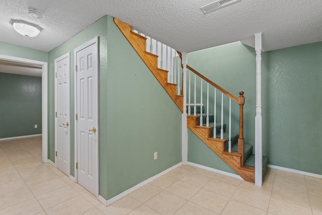 8756 W Farm Rd Unit 124, Springfield, MO 65802 - stairs featuring a textured ceiling and tile patterned flooring